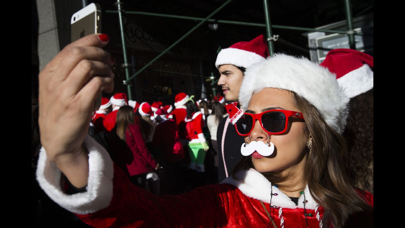 A woman poses for a selfie during the annual SantaCon event in New York on Saturday, December 13.