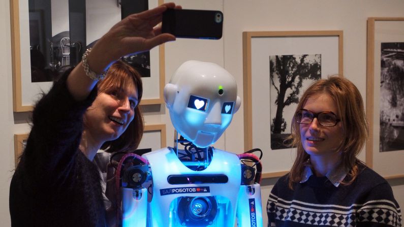 People take a photo with RoboThespian, a life-sized humanoid robot, at a museum in St. Petersburg, Russia, on Wednesday, December 10.