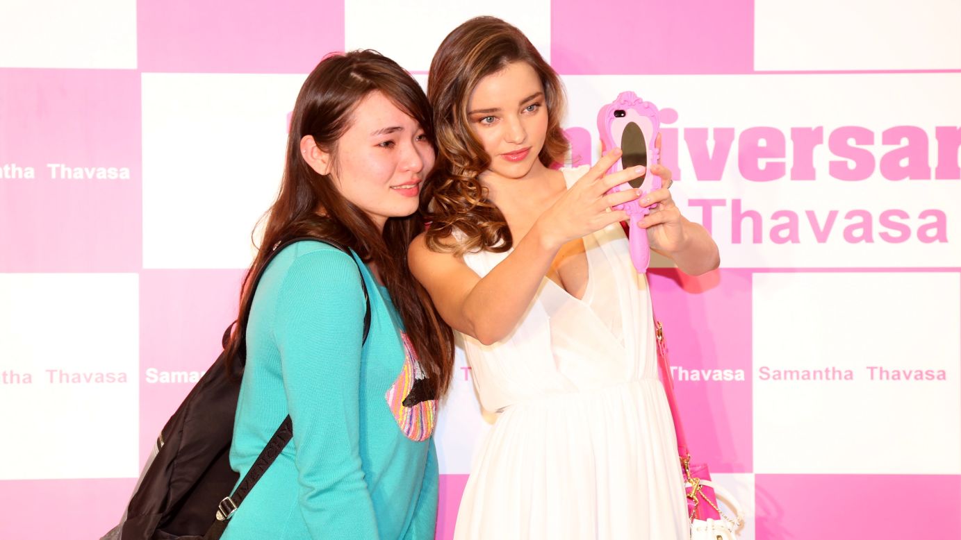 Model Miranda Kerr snaps a selfie Friday, December 12, at the opening ceremony for a new Samantha Thavasa store in Hong Kong.