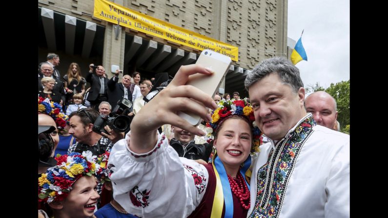 Ukrainian President Petro Poroshenko smiles for a selfie while he visits Ukrainians living in Melbourne on Thursday, December 11