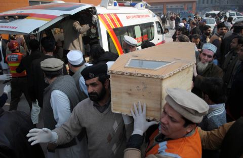 A victim's coffin is carried from an ambulance.