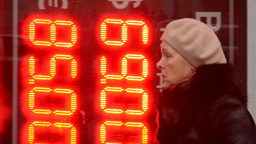 A woman walks past a board listing foreign currency rates against the Russian ruble outside an exchange office in central Moscow on December 16, 2014. The Russian ruble set a new all-time record low on Tuesday after bouncing back briefly despite an emergency move by Russia's central bank to raise interest rates to 17 percent. AFP PHOTO / KIRILL KUDRYAVTSEV (Photo credit should read KIRILL KUDRYAVTSEV/AFP/Getty Images