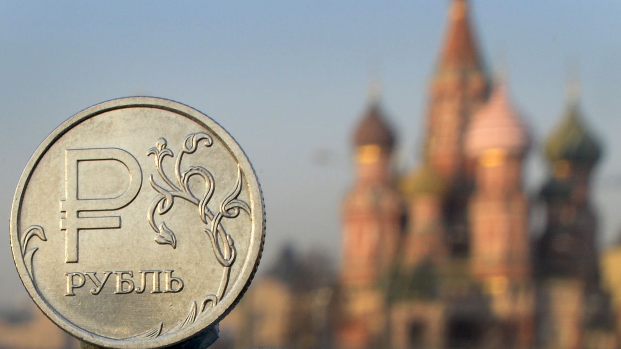 A Russian ruble coin is pictured in front of St. Basil cathedral in central Moscow, on November 20, 2014.