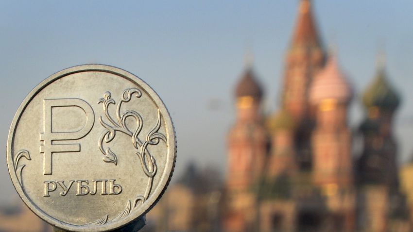 A Russian ruble coin is pictured in front of St. Basil cathedral in central Moscow, on November 20, 2014.