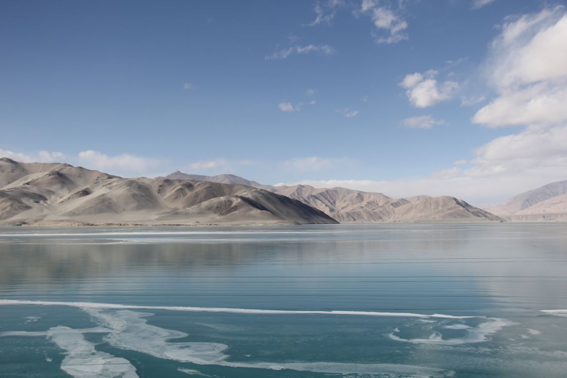 El lago Karakul está situado a una altitud de 3.600 metros sobre el nivel del mar y a unos 200 km de la ciudad china de Kasgar. También es conocido como "lago negro", y su agua posee una espectacular gama de colores desde un verde oscuro hasta un azul celeste incandescente, la cual se ve aún más fascinante a través de su famosa superficie cristalina.