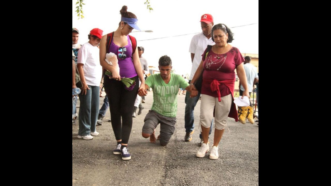 Cubans celebrate St. Lazarus Day on Wednesday, December 17, by converging on a church known as "El Rincon" outside Havana. "A deity for followers of both Catholicism and <a href="http://www.britannica.com/EBchecked/topic/523208/Santeria" target="_blank" target="_blank">Santeria</a>, St. Lazarus is believed to grant good health to the faithful," Oppmann notes. "Many believe they need to show their devotion by suffering." Here, a man receives help as he walks on his knees to the church.