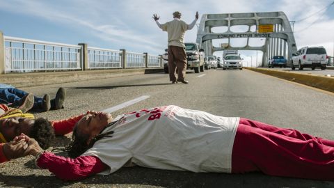Faya Rose Toure (in white shirt) lies on the Edmund Pettus Bridge to block traffic in a protest against a police shooting in Selma.