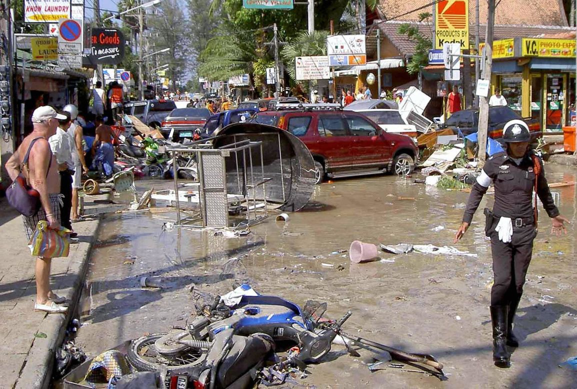 Foreign tourists look at damage caused by the tsunami in Phuket on December 26, 2004. 