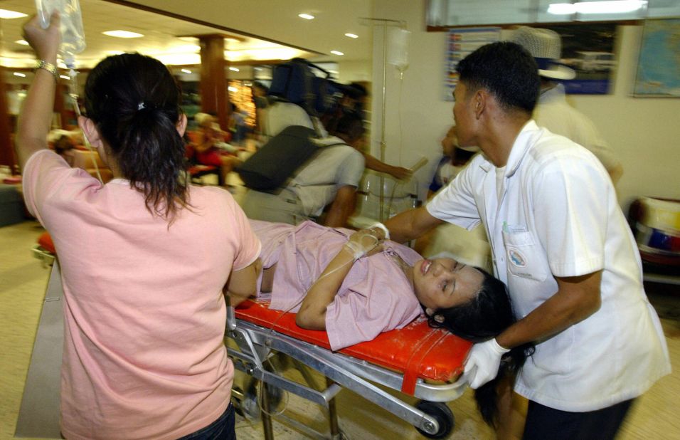 Thai medical staff rush a victim of tidal waves to the operating theater at Phuket International Hospital on December 26, 2004. At least 310 people were killed and more than 5,000 injured in southern Thailand.