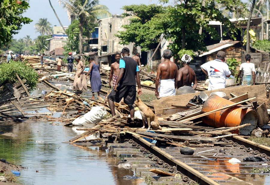 Residents wade through the trail of destruction along the coastal railway line in the southern town of Lunawa after tsunami tidal waves lashed more than half of Sri Lanka's coastline.