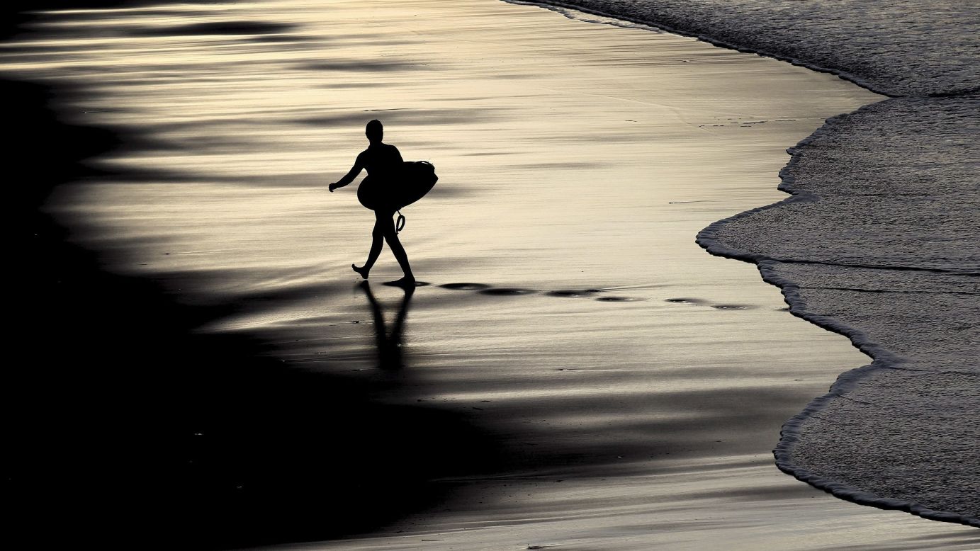 A surfer makes his way out of the water Monday, December 15, at Zurriola Beach in San Sebastian, Spain.