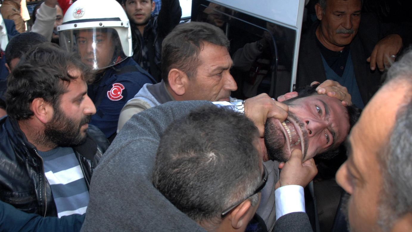 Plain-clothed police officers in Adana, Turkey, detain a man who was trying to set up a tent Monday, December 15, to mourn those killed in Kobani, Syria. Kobani, near the Turkish border, <a href="http://www.cnn.com/2014/12/10/world/meast/nick-paton-walsh-reddit-ama/index.html" target="_blank">has been devastated</a> by heavy fighting between Kurdish forces and ISIS militants.