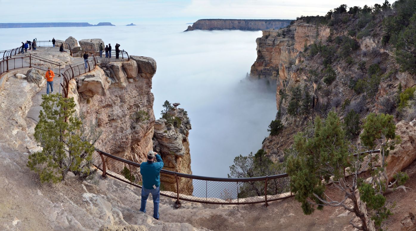 Visitors at Mather Point, on the South Rim of Arizona's Grand Canyon National Park, view a rare weather phenomenon on Thursday, December 11: a sea of thick clouds filling the canyon just below the rim.