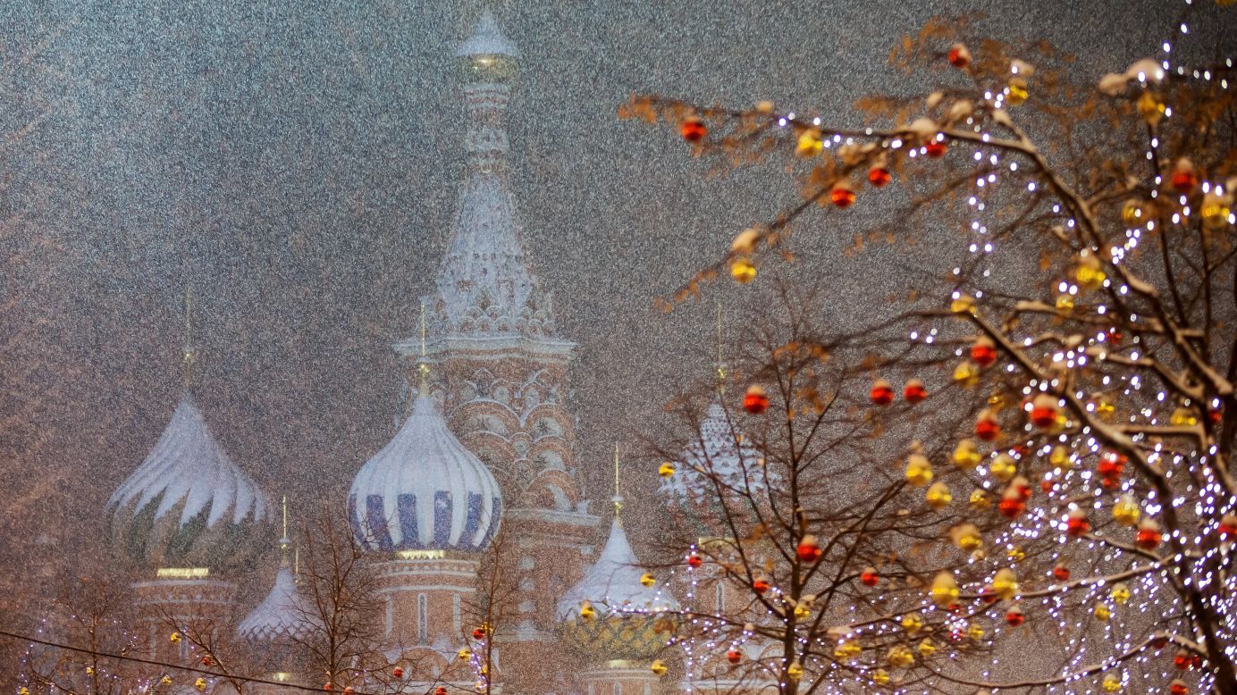 Trees are decorated with Christmas lights on Friday, December 12, as snow covers St. Basil's Cathedral in Moscow's Red Square.