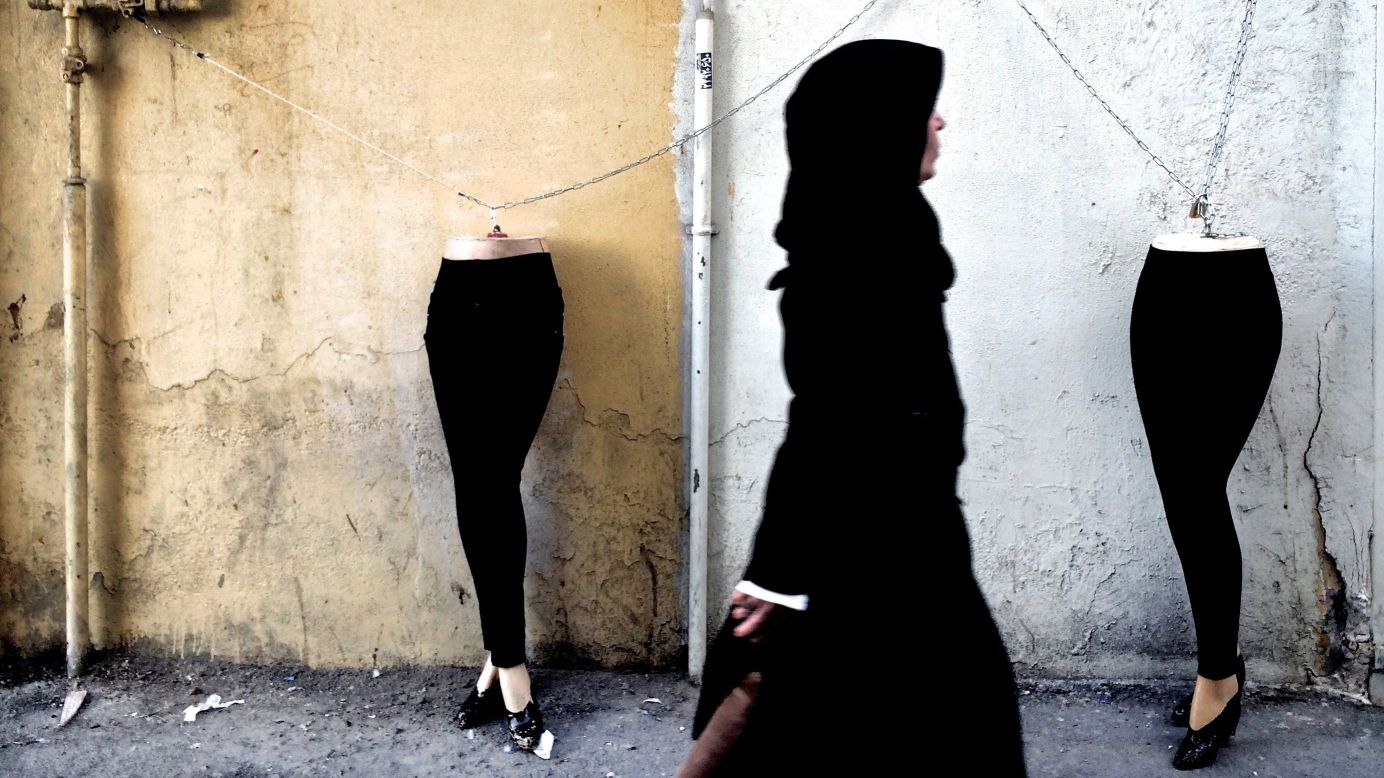 A woman walks past mannequins that were locked to a gas pipe in Tehran, Iran, on Monday, December 15.