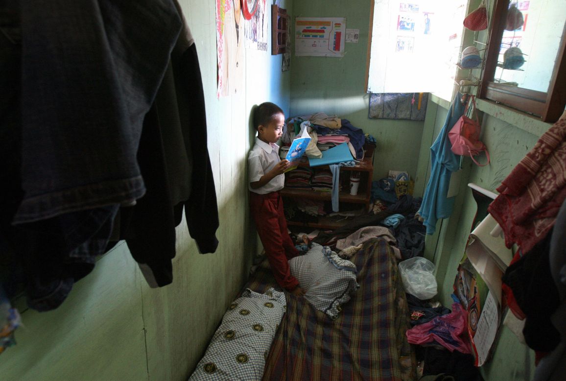 Tsunami victim Heru checks his homework inside his family's room at a temporary housing complex in Banda Aceh on December 12, 2006. Two years after the Indian Ocean tsunami wiped out their neighborhoods, many survivors struggled to understand why their homes have not been rebuilt.