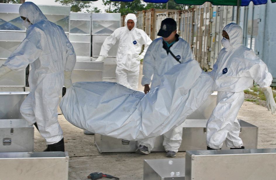 Two years later on December 6, 2006, Thai workers carry the body of an unidentified victim of the 2004 tsunami to be buried at Bang Maruan cemetery, in Thailand's southern province of Phang Ng. Thailand buried the last of its unknown victims in a quiet ceremony attended by a handful of officials and Buddhist monks.