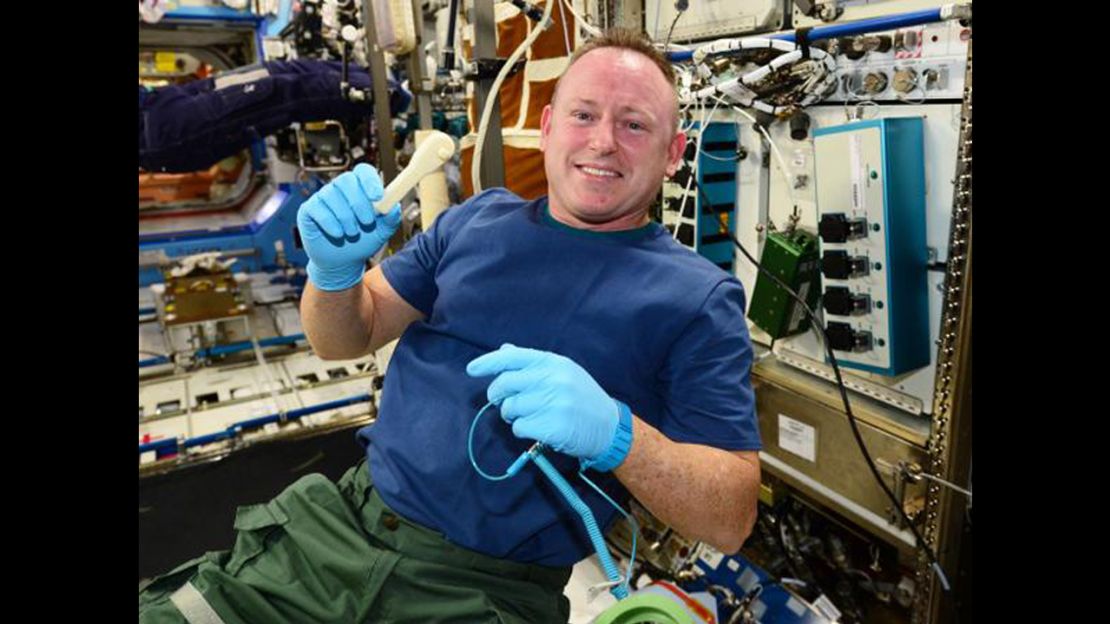Astronaut Barry "Butch" Wilmore holds up the ratchet after removing it from the print tray.