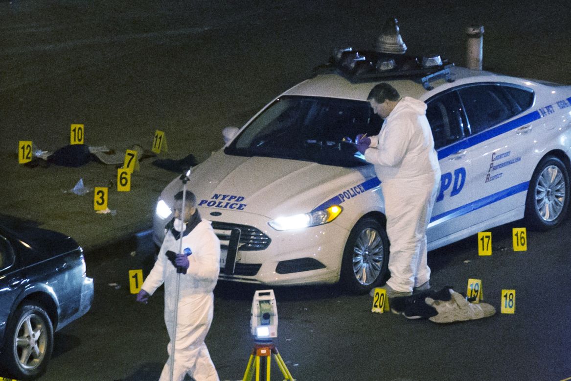 Investigators work the scene where two NYPD officers were shot December 20, in the Bedford-Stuyvesant neighborhood of Brooklyn, New York. 