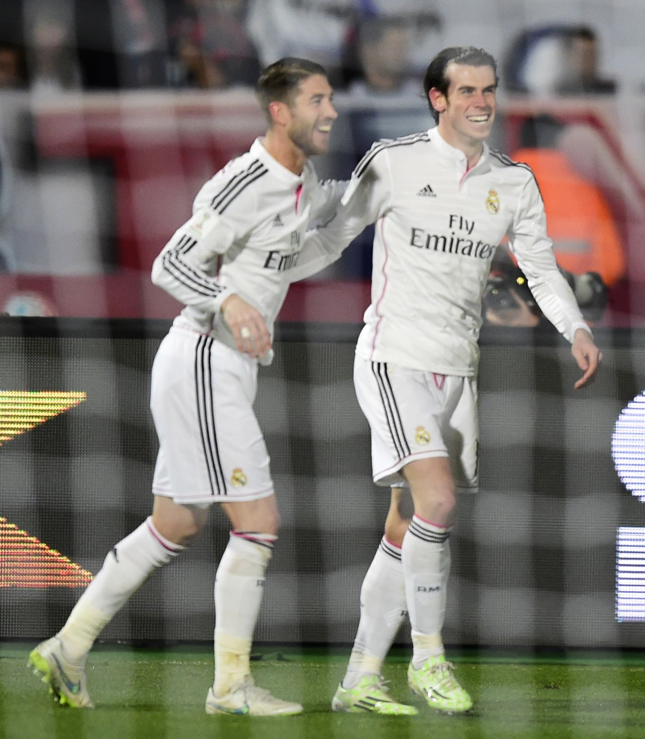 But the smiles are soon back for Real Madrid when Gareth Bale (right) scores a second goal against San Lorenzo.