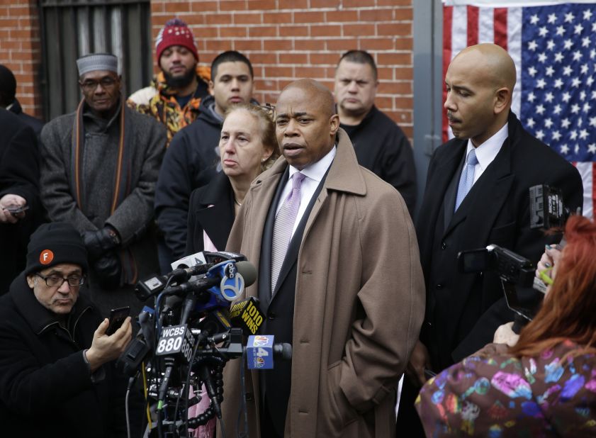 Brooklyn Borough President Eric Adams, third from right, speaks on December 21 while Manhattan Borough President Gale Brewer, fourth from right, and Bronx Borough President Ruben Diaz, right, listen during a news conference at an impromptu memorial near the site where the officers were shot. 