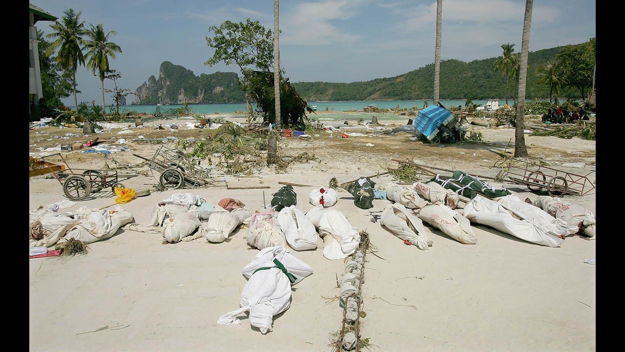 Bodies lay covered in the street waiting to be transported by boat from Phi Phi Village to Phuket and Krabi on December 28, 2004. 