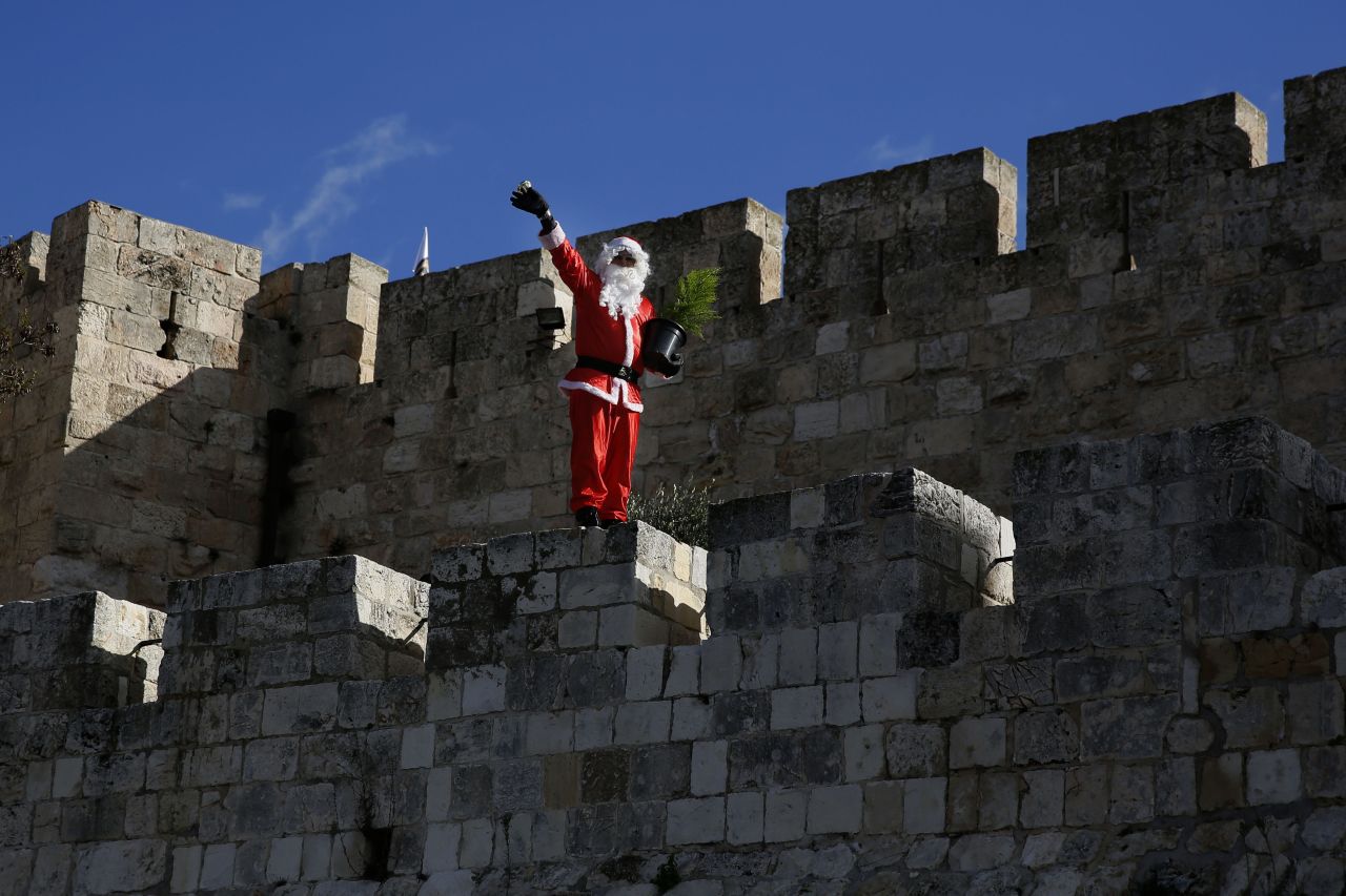 Santa waves to passers-by as he walks along Jerusalem's Old City walls.