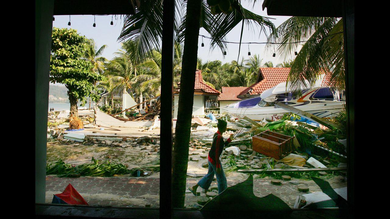 A Thai woman walks by the devastation at a hotel along Patong Beach on December 27, 2004, in Phuket.