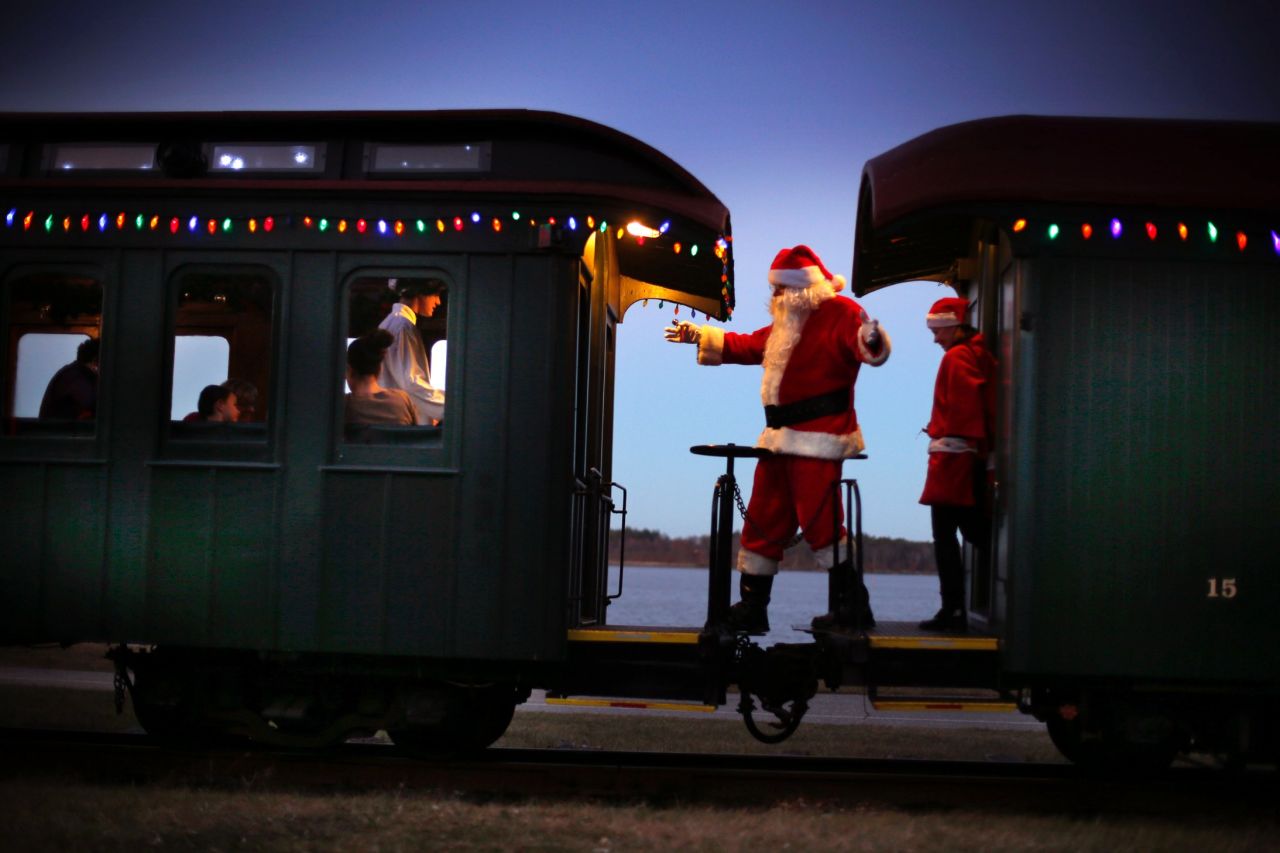 Santa greets passengers while moving between cars during the Polar Express train ride, a holiday fundraiser at the Maine Narrow Gauge Railroad Co. and Museum in Portland.