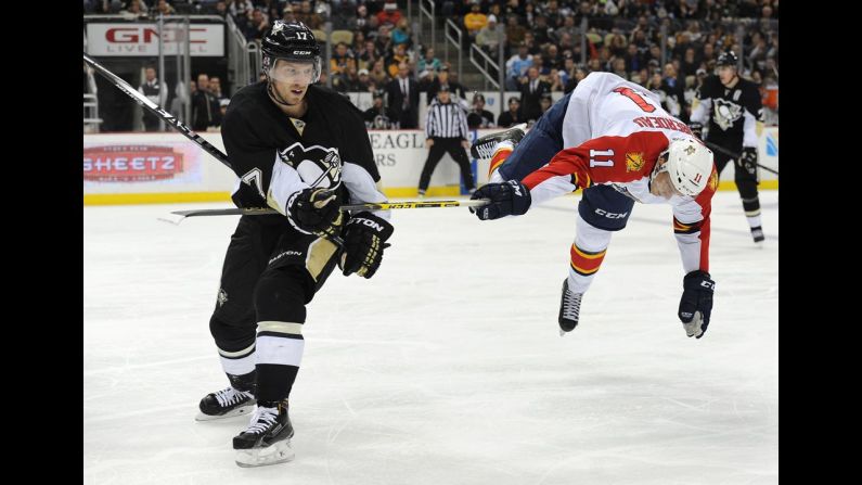 Pittsburgh Penguins left wing Blake Comeau, left, checks Florida Panthers center Jonathan Huberdeau during the third period of an NHL hockey game.