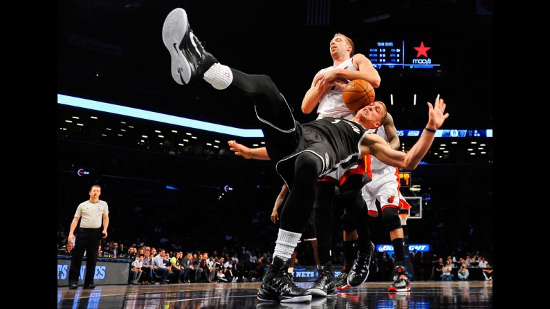 Justin Hamilton of the Miami Heat fights for the ball with Mason Plumlee, front, of the Brooklyn Nets at the Barclays Center on December 16, in Brooklyn, New York.