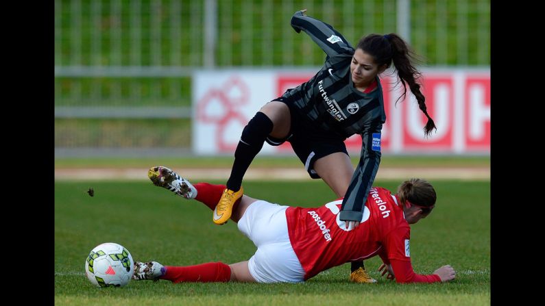Manjou Wilde of Freiburg, standing, plays against Katrin Posdorfer of Guetersloh during the women's soccer cup quarter-final match on December 21, in Breisgau, Germany.  
