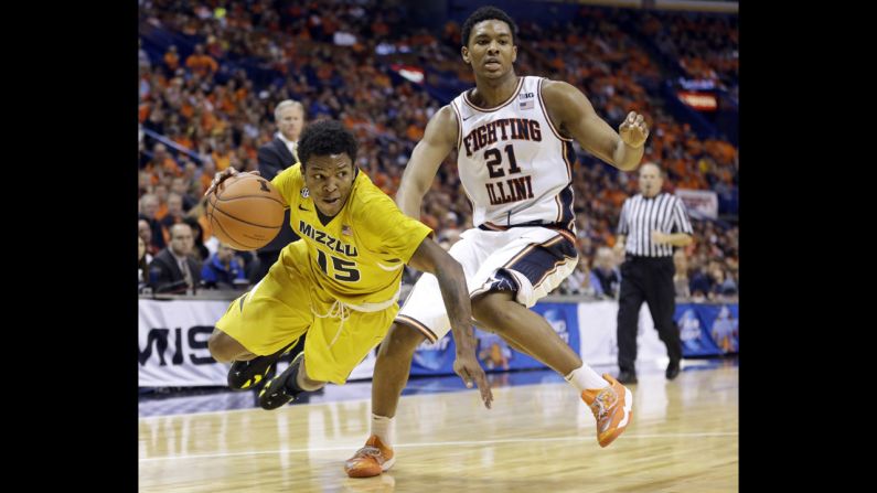 Missouri's Wes Clark, left, falls as he tries to maneuver past Illinois' Malcolm Hill on December 20 in St. Louis. 