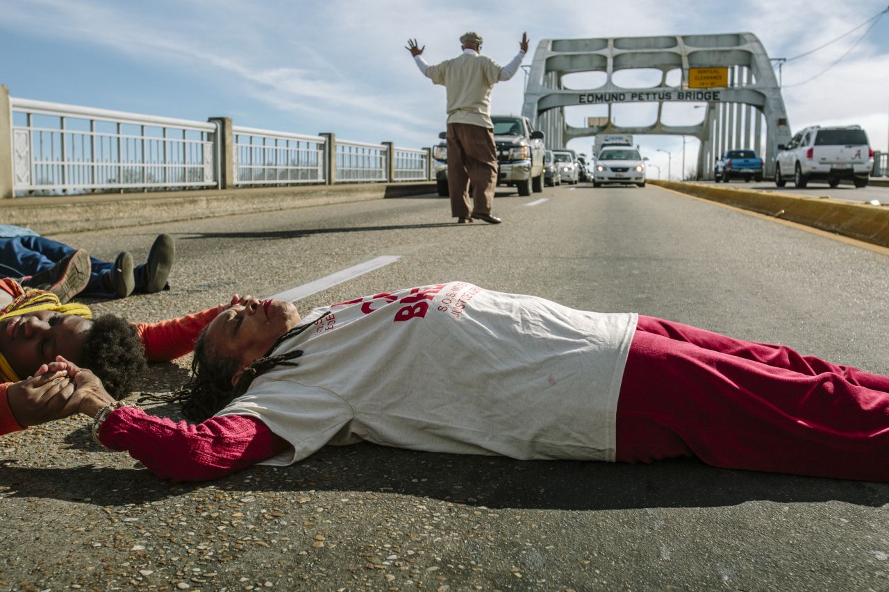 Longtime activist Faya Rose Toure leads a "die-in" on the Edmund Pettus Bridge, a prominent landmark in Selma, Alabama. Police attacked civil rights marchers on the bridge 50 years ago at a protest that became known as "Bloody Sunday." Toure evokes Selma's past in her attempts to change the present.