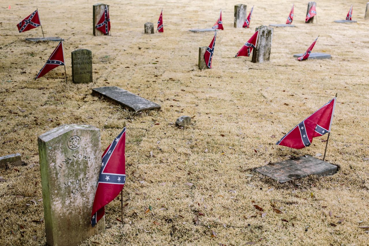 Confederate flags mark graves at Live Oak Cemetery. Controversy erupted after the city approved a new monument at the cemetery that honors Nathan Bedford Forrest, a Confederate general accused of massacring black soldiers and a "grand wizard" of the Ku Klux Klan. 