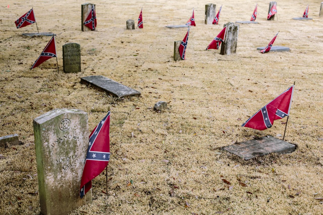 Confederate flags mark graves at Live Oak Cemetery. Controversy erupted after the city approved a new monument at the cemetery that honors Nathan Bedford Forrest, a Confederate general accused of massacring black soldiers and a "grand wizard" of the Ku Klux Klan.