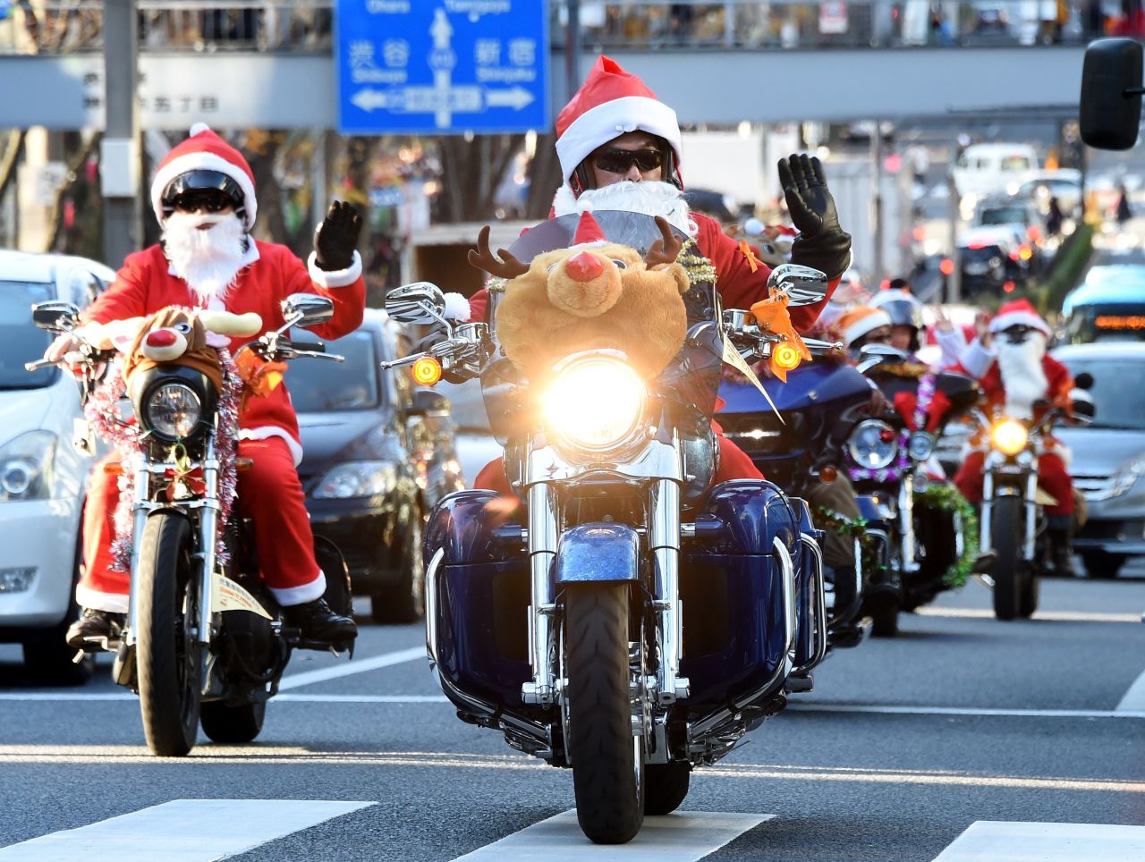 Motorcyclists in Santa and reindeer outfits ride through the streets of Tokyo.
