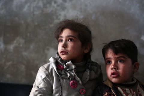 Syrian children await medical treatment at a makeshift clinic in the besieged rebel town of Douma, on Sunday, December 21, near Damascus.