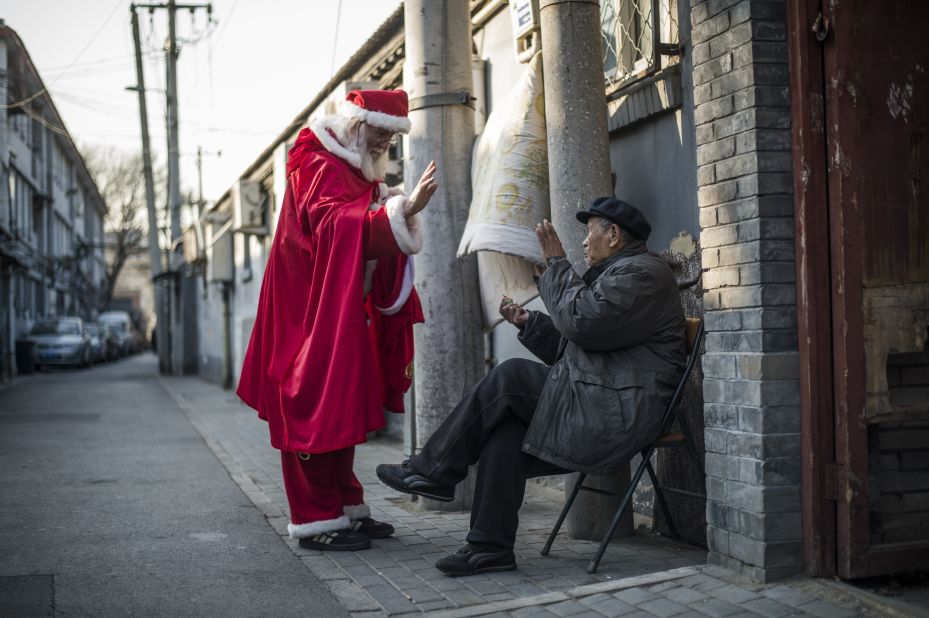 A Santa gives out sweets to a man in Beijing.