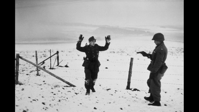 Mid-December 1944 saw the beginning of the six-week Battle of the Bulge on Europe's Western Front. War photographer Robert Capa immersed himself with Allied troops. Here, an American soldier points a gun at a German prisoner of war.