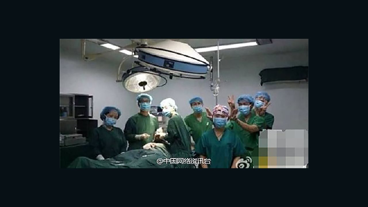 Doctors pose for a photo next to a patient in an operating theater at Fengcheng Hospital in August 2014.