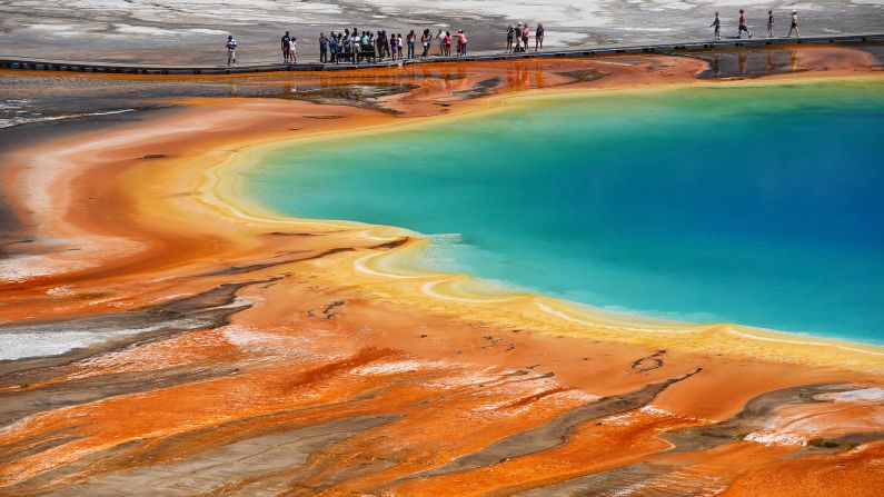 The largest hot spring in Yellowstone, Grand Prismatic Spring is about 300 feet (90 meters) across and 165 feet (50 meters) deep. At 188 degrees Fahrenheit, the bright blue water at the center of the pool is too hot to support life, but bacteria and algae thrive along the edges. The heat-loving bacteria produce orange, yellow and red pigments as a natural sunscreen, creating the spring's psychedelic look.