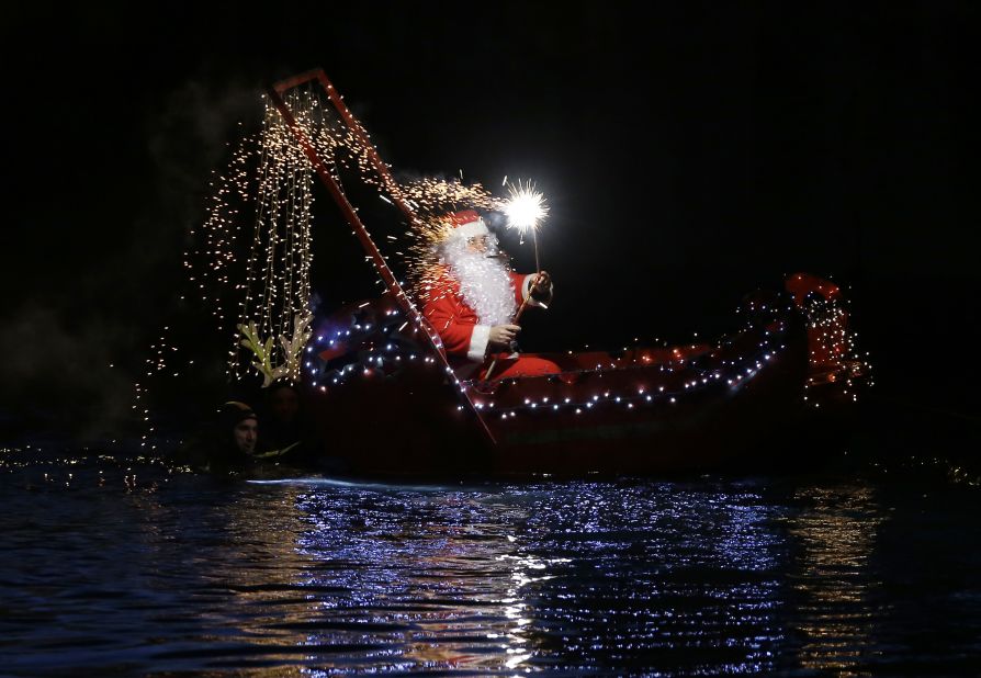 A Santa Claus lights a flare while riding in a boat in Imperia, Italy. Click through the gallery for more photos of all the places Santa has shown up over the years: 