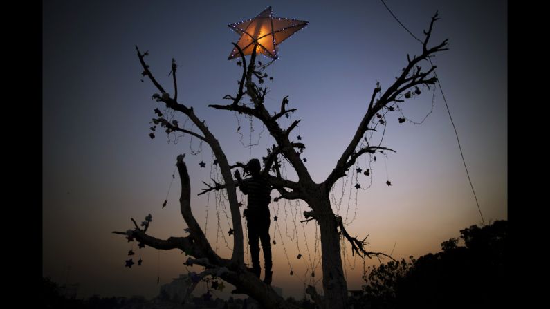 A Pakistani boy decorates a tree before Christmas in Islamabad's slums, on Tuesday, December 23.