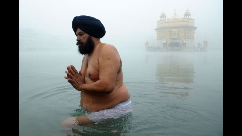 An Indian Sikh takes a dip near the Golden Temple in Amritsar on Wednesday, December 24, on a foggy morning. 