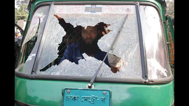 A man looks out a broken window after clashes between Bangladesh Nationalist Party supporters and government supporters on Wednesday, December 24, before BNP chairperson Khaleda Zia arrived at court.