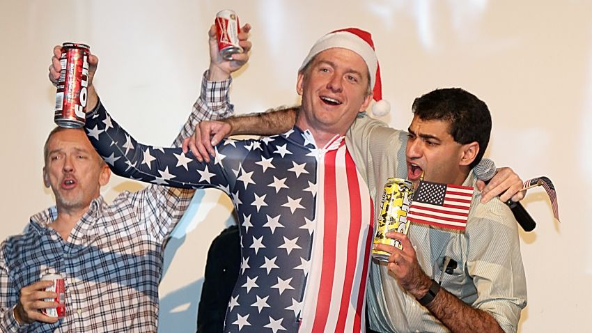 Caption:AUSTIN, TX - DECEMBER 25: Alamo Drafthouse Co-Founder and CEO Tim League, wearing a US Flag jumper and Santa hat, leads movie goers on a sing along of 'Proud To Be An American' before a screening of Sony Pictures' 'The Interview' which opens on Christmas Day, December 25, 2014 in Austin, Texas. Sony hackers have been releasing stolen information and threatened attacks on theaters which screened the film. (Photo by Gary Miller/WireImage/Getty Images)