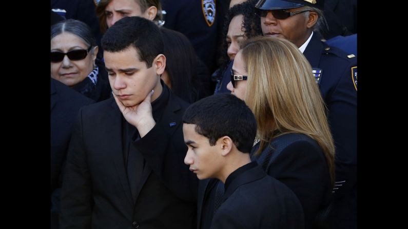 Justin Ramos is comforted by his mother following the funeral service.