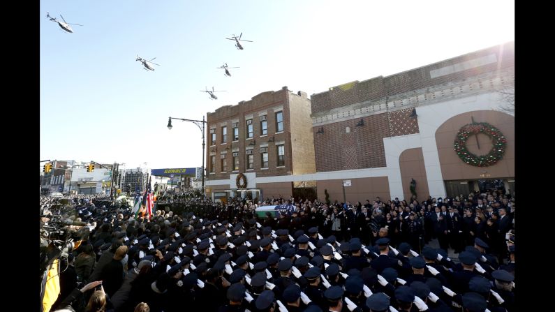 Law enforcement helicopters fly over Christ Tabernacle in Queens, where the casket of New York City police officer Rafael Ramos is carried by pallbearers, on Saturday, December 27. Ramos and Officer Wenjian Liu were shot and killed while they sat in their patrol car in Brooklyn on December 20.