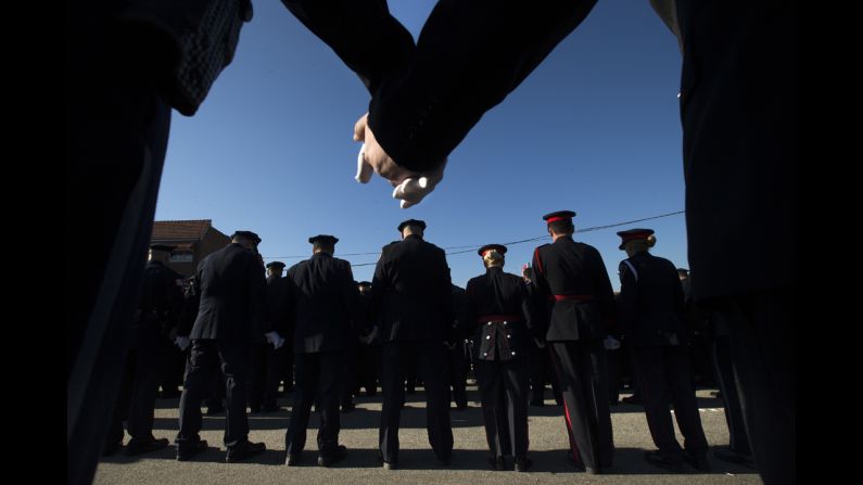 Police officers hold hands in prayer during the funeral services.